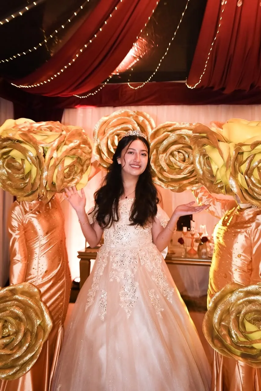 Quinceañera rodeada de personajes de rosas doradas