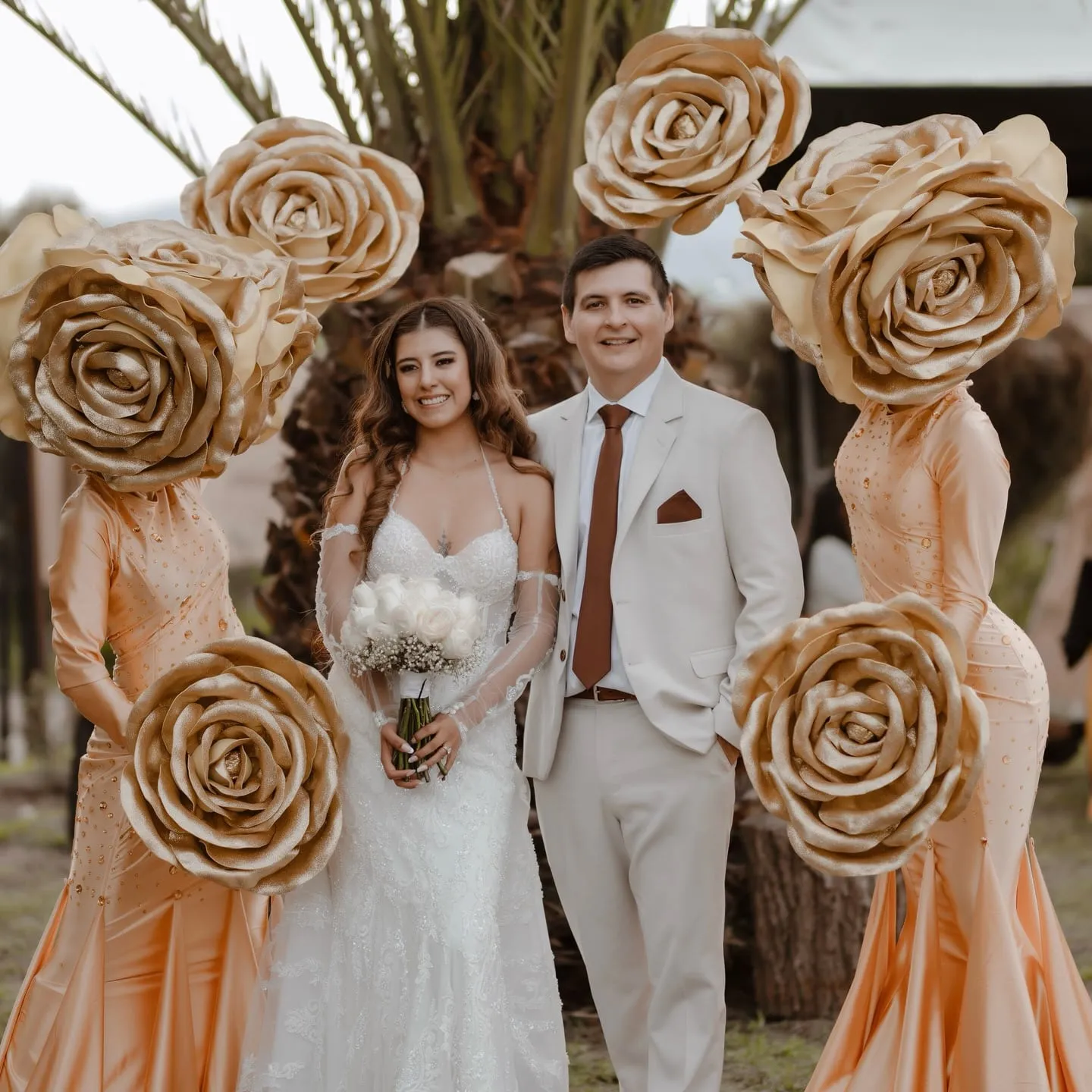 Novios junto a personajes de rosas doradas