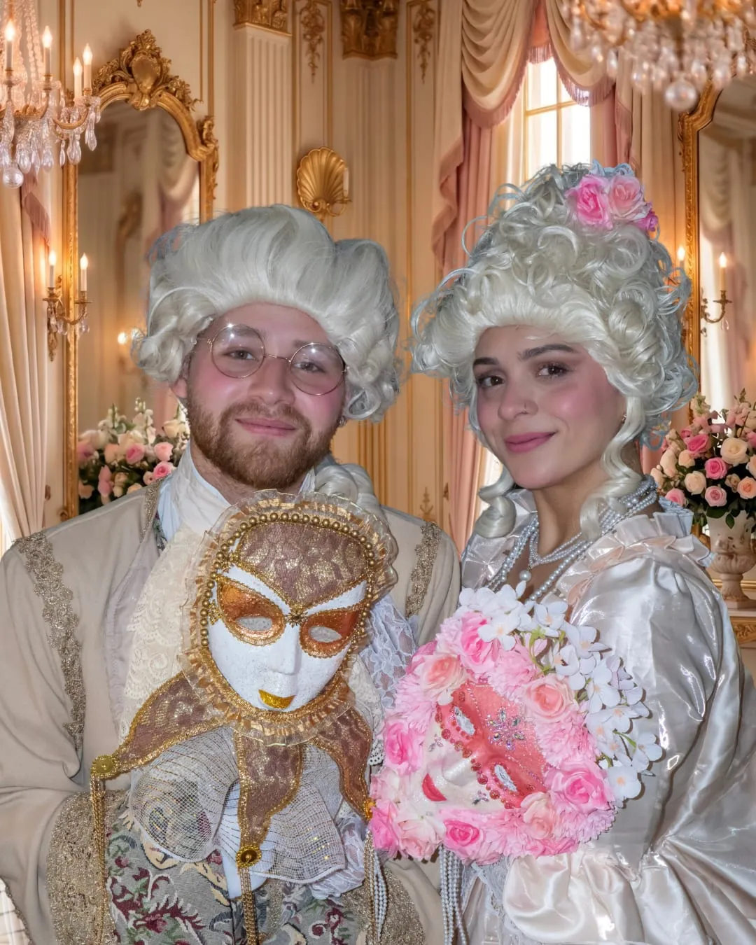 Pareja con vestuario de época y máscaras venecianas